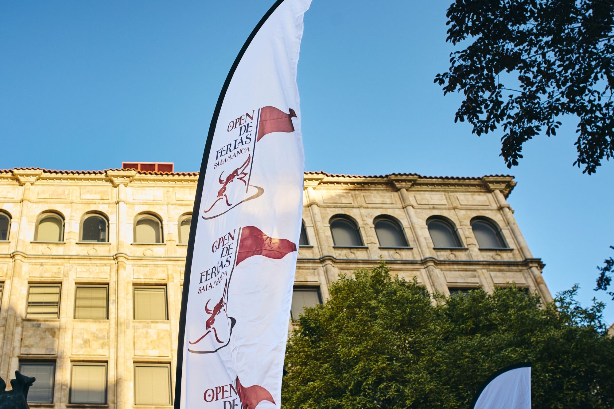 Banderola del Open de Ferias ondeando frente a un edificio histórico del centro de Salamanca