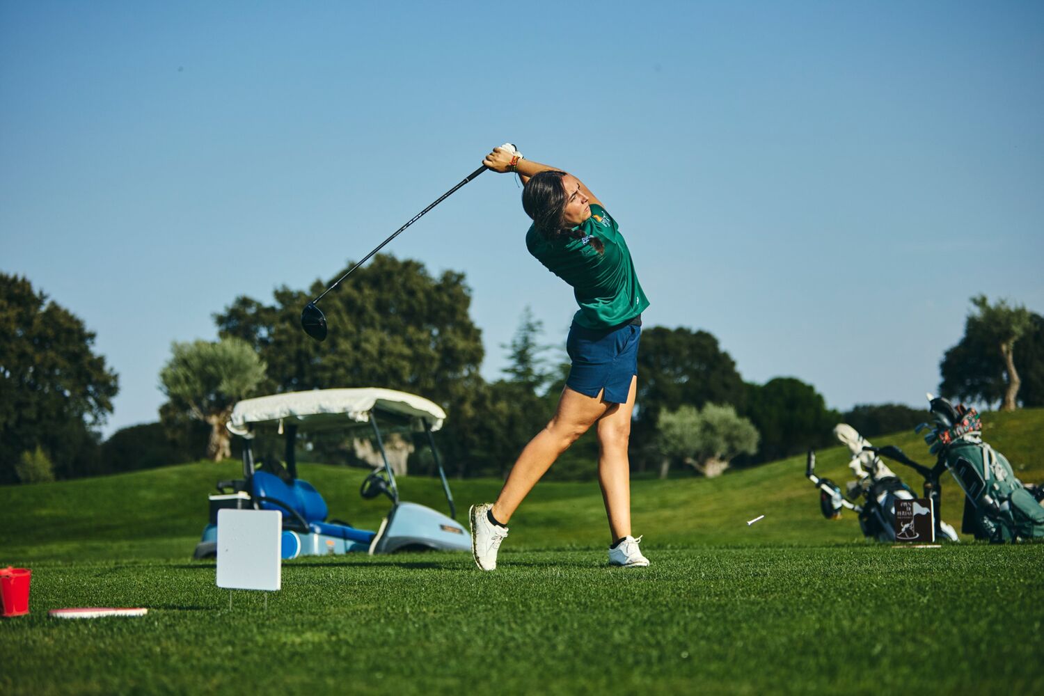 Jugadora terminando el swing con el driver desde el tee